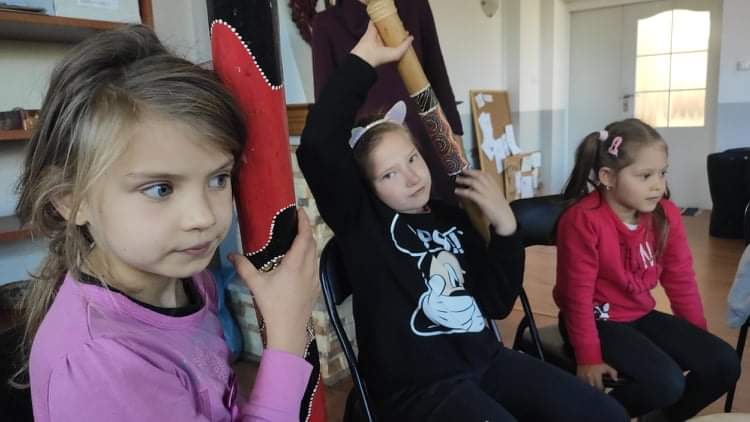 Dziewczynki przykładają uch do instrumentów